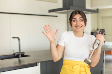 Genç bir kadın inanılmaz bir şey karşısında kendini mutlu ve şaşkın hissediyor. El blendırlı şef