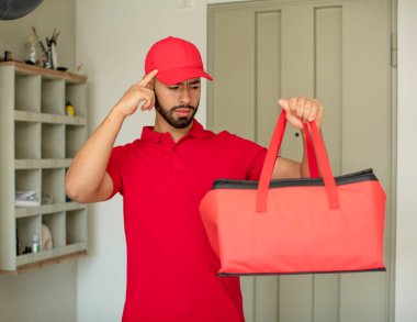 Genç yetişkin bir adam şaşırmış görünüyor, yeni bir düşünce, fikir ya da konsept fark ediyor. Pizza teslimatçısı konsepti