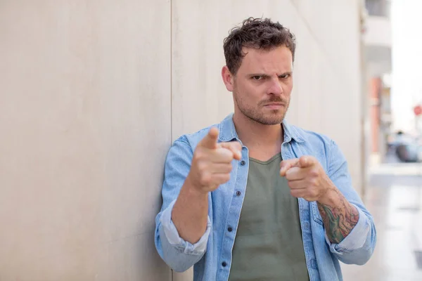 Yakışıklı Bir Adam Kamerayı Iki Parmağıyla Kızgın Bir Ifadeyle Sana — Stok fotoğraf