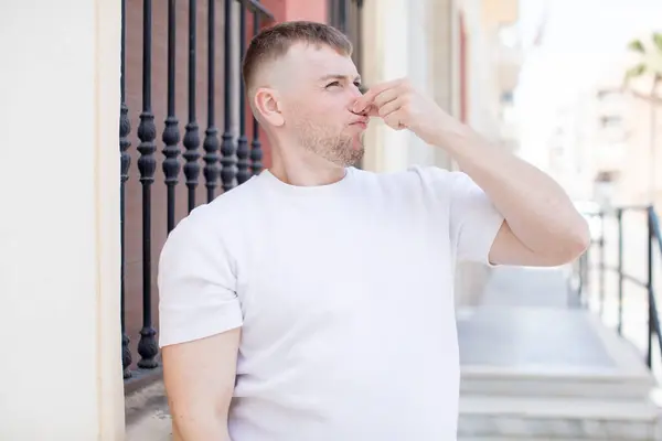 Homem Bonito Sentindo Enojado Segurando Nariz Para Evitar Cheirar Fedor — Fotografia de Stock