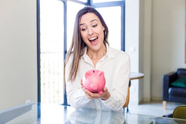 young adult pretty woman with a piggy bank. money and savings concept