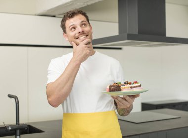 Mutlu ve kendinden emin bir ifadeyle gülümsüyor. Ev yapımı kek konsepti