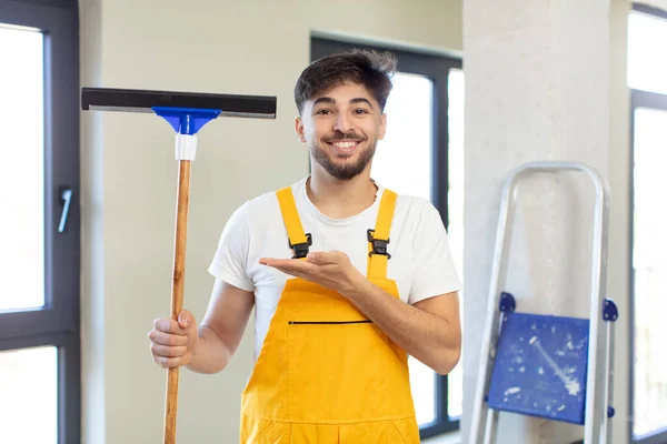 stock image young handsome man smiling cheerfully, feeling happy and showing a concept. windows washer concept