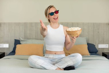 Mutlu bir şekilde gülümsemek ve bir konsept sunmak veya göstermek. film ve patlamış mısır konsepti