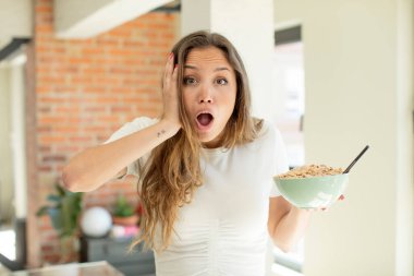 Güzel bir kadın son derece şaşırmış ve şok olmuş hissediyor. Kahvaltı kasesi konsepti
