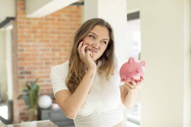 Güzel bir kadın bıkkın, hayal kırıklığına uğramış ve yorucu bir geceden sonra uykulu hissediyor. Domuz kumbarası konsepti