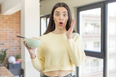 Oldukça genç bir model son derece şaşkın ve şaşırmış hissediyor. Kahvaltı kasesi konsepti