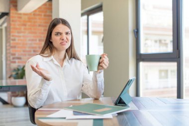 Genç, güzel bir kadın omuz silkiyor, kafası karışık ve kararsız. Evden işe dolaşma kavramı