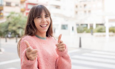 Güzel genç bir kadın kendini mutlu, sakin, tatmin olmuş, rahat ve başarılı hissediyor, kameraya bakıyor, seni seçiyor.