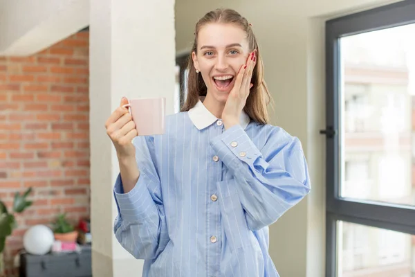 stock image feeling happy and astonished at something unbelievable. coffee mug at home. coffee mug at home