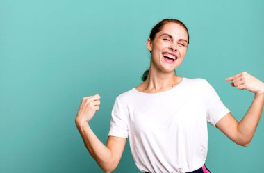 Beyaz gömlek ve fotokopi alanı giyen genç ve güzel bir kadın.