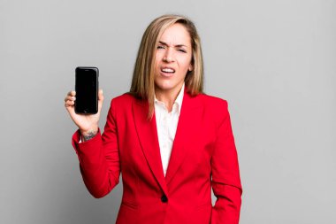 Güzel sarışın kadın şaşkın ve şaşkın hissediyor. İş kadını ve telefon konsepti