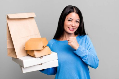 İspanyol güzel kadın kendini mutlu hissediyor ve bir meydan okumayla yüzleşiyor ya da kutluyor. Fast food paketleriyle birlikte.