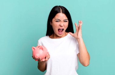 İspanyol güzel kadın ellerini havaya kaldırıp domuz kumbarasıyla bağırıyor.