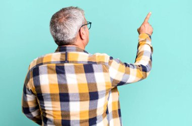 Orta yaşlı adam dikey görünüm ve kopyalama alanı üzerinde duran ve nesneyi işaret eden