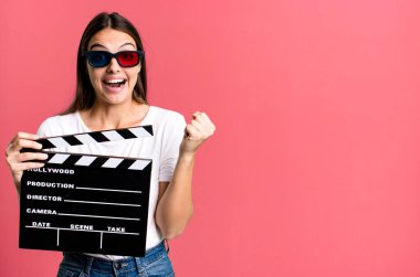 Genç ve güzel bir kadın şokta, gülüyor ve başarıyı kutluyor. Sinema filmi veya film konsepti