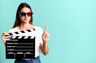 Genç, güzel bir bayan gülümsüyor ve arkadaş canlısı görünüyor. Bir numarayı gösteriyor. Sinema filmi veya film konsepti