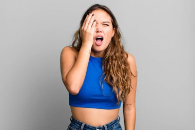 Genç ve güzel bir kadın uykulu görünüyor, sıkılmış ve esniyor, baş ağrısı ve yüzünün yarısını kaplayan bir eliyle