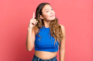 Genç ve güzel bir kadın, harika bir fikri fark ettikten sonra parmağını havaya kaldırıp 