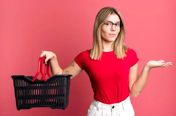 Young Pretty Woman Feeling Puzzled Confused Doubting Empty Shopping Basket — Photo