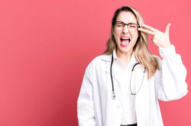 Mutsuz ve stresli görünüyor, intihar jesti silah işareti yapıyor. Tıp öğrencisi ya da doktor.