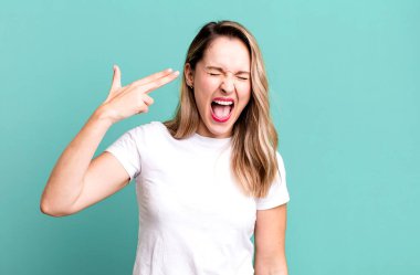 Mutsuz ve stresli görünüyor, intihar jesti elle silah işareti yapıyor, kafasını işaret ediyor.