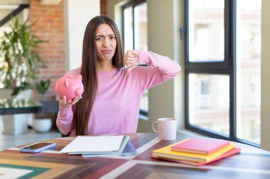 Çapraz hissetmek, baş parmakları aşağı göstermek. Domuz kumbarası konsepti