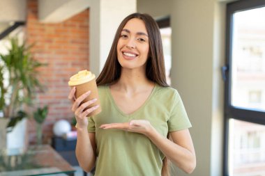Neşeli bir şekilde gülümsemek, mutlu olmak ve bir konsept göstermek. kahve konseptini kaldır.