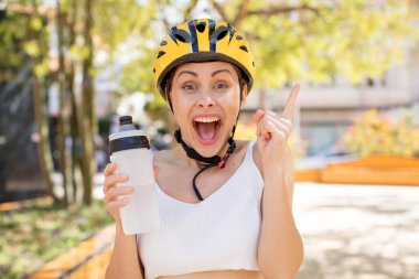 Genç ve güzel bir kadın bir fikri fark ettikten sonra mutlu ve heyecanlı bir dahi gibi hissediyor. bisiklet kaskı konsepti