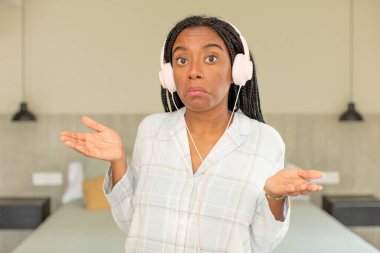 Siyah afro kadın omuz silkiyor, kafası karışık ve kararsız. dinlenme ve gecelik konsepti