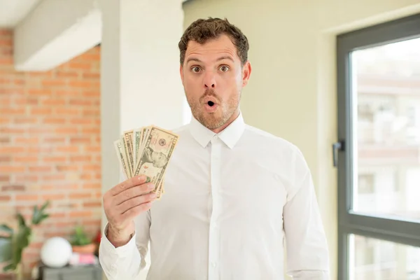 stock image feeling extremely shocked and surprised. dollar banknotes concept