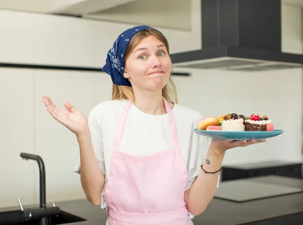 Young Pretty Woman Shrugging Feeling Confused Uncertain Home Made Cakes — Stockfoto