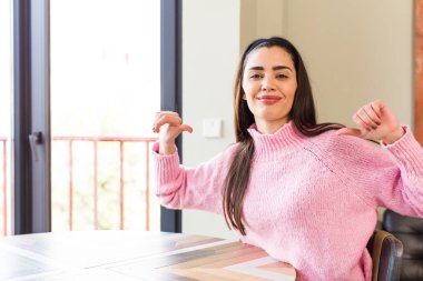 pretty caucasian woman feeling proud, arrogant and confident, looking satisfied and successful, pointing to self