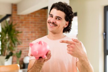 Kumbaralı genç ve yakışıklı bir adam. ev içi tasarruf kavramı