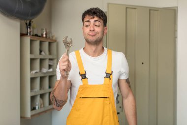 Genç ve yakışıklı bir adam gülümsüyor ve kendine güveni tam bir ifadeyle bakıyor. Becerikli adam kavramı