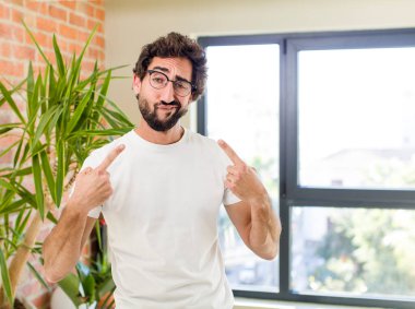 young adult crazy man with expressive pose at a modern house interior