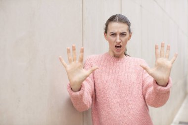 Güzel bir kadın sersemlemiş ve korkmuş hissediyor. Korkutucu bir şeyden korkuyor. Elleri açık ve uzak dur diyor.