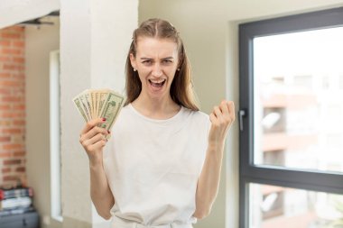 Kızgın, sinirli ve hayal kırıklığına uğramış görünüyor. Dolar banknotları konsepti