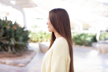 Profil görünümünde genç ve güzel bir kadın ilerideki boşluğu kopyalamaya çalışıyor, düşünüyor, hayal ediyor ya da hayal kuruyor.