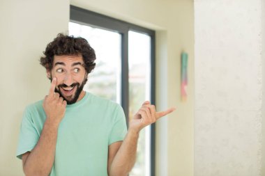 Genç çılgın sakallı adam bir şeye göz kulak oluyor, izliyor, tetikte ve tetikte.