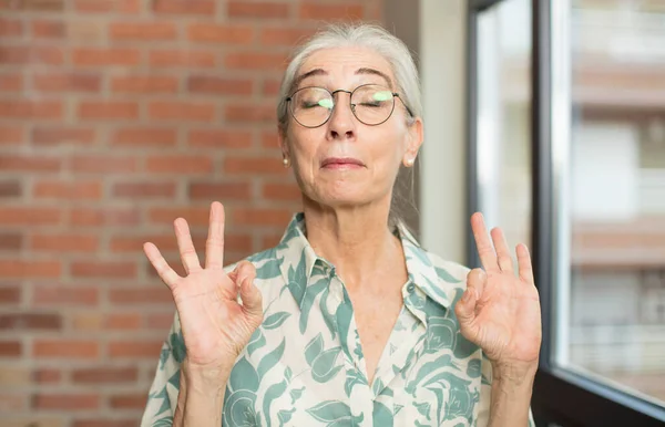 Seniorka Hezká Žena Která Vypadá Soustředěně Medituje Cítí Spokojená Uvolněná — Stock fotografie