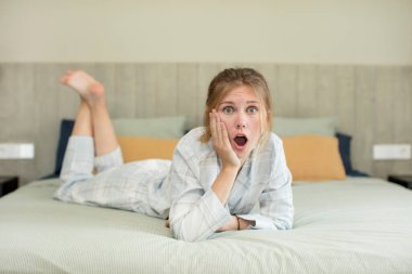 Genç ve güzel bir kadın şok olmuş ve şaşırmış hissediyor. gece kıyafeti konsepti
