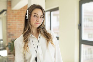 Güzel bir kadın gülümsüyor ve mutlu ve kendinden emin bir ifadeyle bakıyor. tele pazarlamacı kavramı