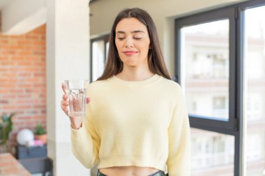 Gülümseyen ve kendine güveni tam genç bir manken. su camı konsepti