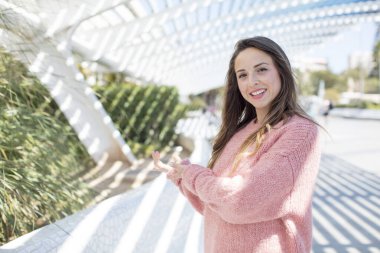 Güzel bir kadın kendini mutlu ve neşeli hissediyor, gülümsüyor ve seni hoş karşılıyor, seni dostça bir jestle içeri davet ediyor.