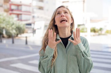 Güzel bir kadın umutsuz ve hayal kırıklığına uğramış, stresli, mutsuz ve sinirli, bağırıyor ve çığlık atıyor.