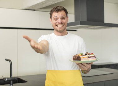 Mutlu bir şekilde gülümsemek ve bir konsept sunmak veya göstermek. Ev yapımı kek konsepti