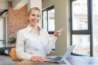 Neşeli bir şekilde gülümsüyor, mutlu hissediyor ve bir tarafı işaret ediyor. İş kadını kavramı