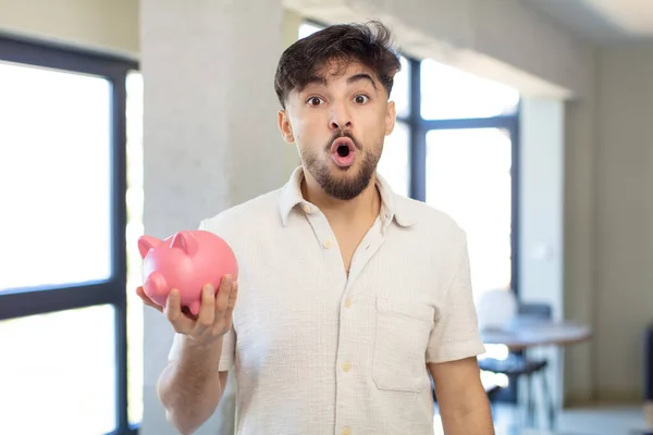 Young Handsome Man Feeling Extremely Shocked Surprised Piggy Bank Concept — Stock Photo, Image