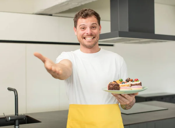 stock image smiling happily and offering or showing a concept. home made cakes concept
